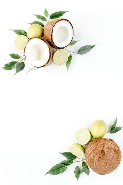 Creative pattern made of summer tropical fruits coconut lime and leaves ficus food concept flat lay