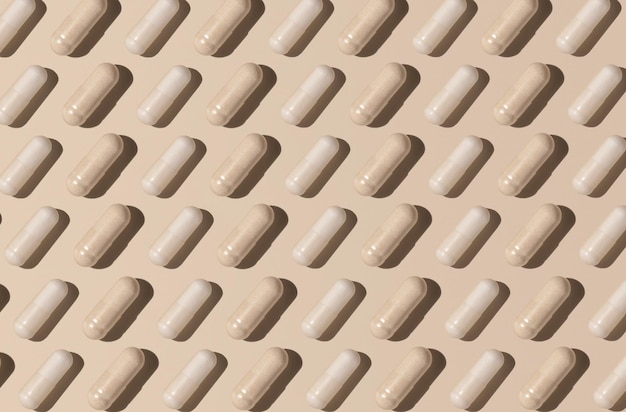 Creative pattern with capsules on light beige top view hard shadows Taking supplements