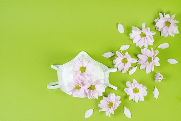 Creative pattern with medical protective mask against diseases, coronavirus and spring flowers