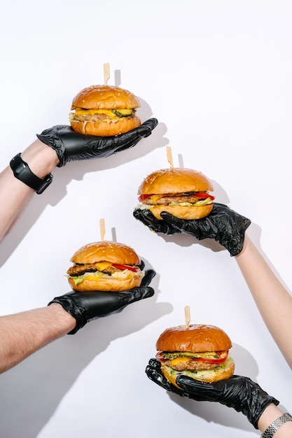 Creative photography of juicy burgers in hands on white background