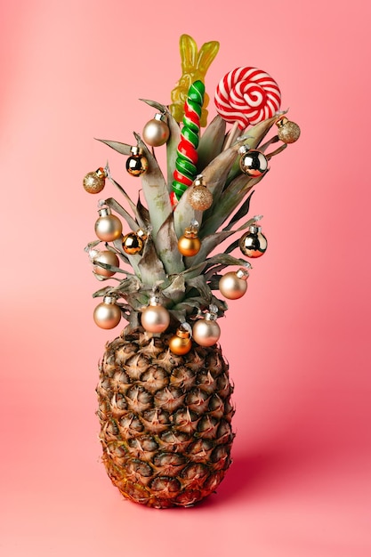 Creative pineapple with Christmas decorations on studio background