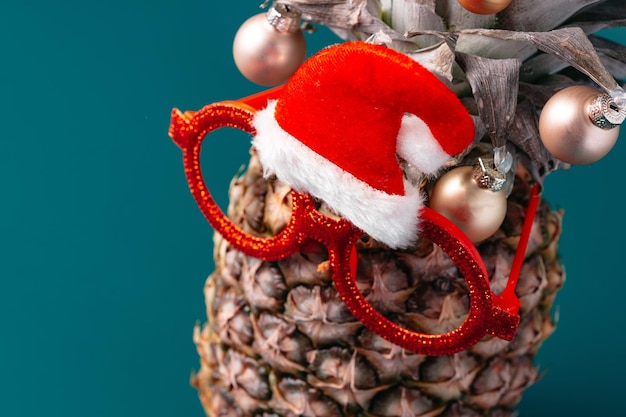 Creative pineapple with christmas decorations on studio background