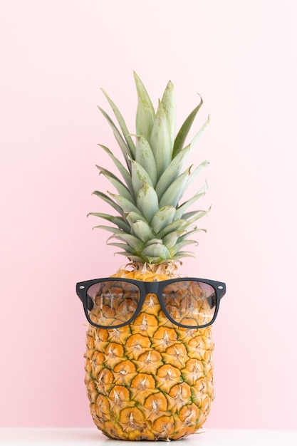 Креативный ананас с солнцезащитными очками, изолированными на цветном фоне летних каникул на пляже