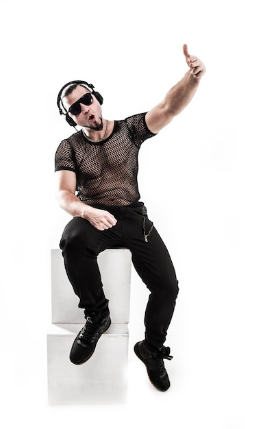 Photo creative rapper in the headphones and dark glasses performs a rap song .photo on a white background and has an empty space for your text
