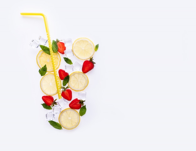 Creative summer drink composition. With lemon slices, mint leaves, strawberry and ice cubes on white