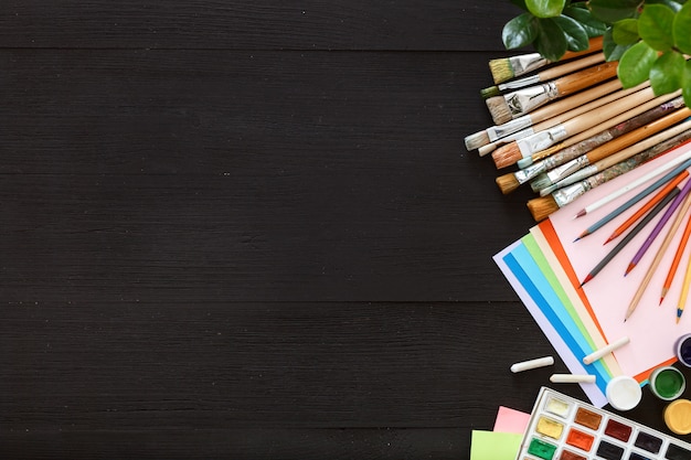 Creative supplies on black wood desk