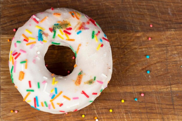 Creative sweet food Glazed colorful donut on a wooden background