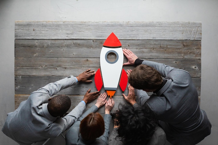 Photo creative team with startup rocket