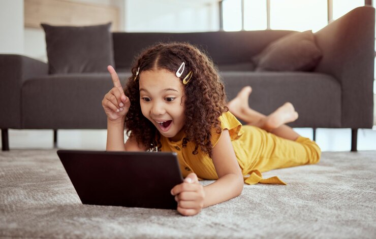 Photo creative thinking tablet learning and girl streaming education video on internet planning idea with tech and excited about web app on living room floor kid with smile and solution to game online