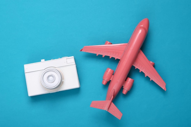 Creative travel ayout toy air plane with white retro camera on
blue background minimalism concept art modern still life flat lay
top view