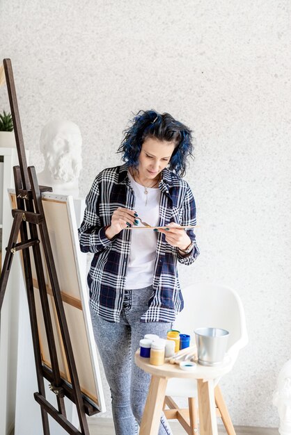 Photo creative woman artist putting oil paints on palette working in her studio