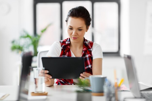 Photo creative woman with tablet pc working at office