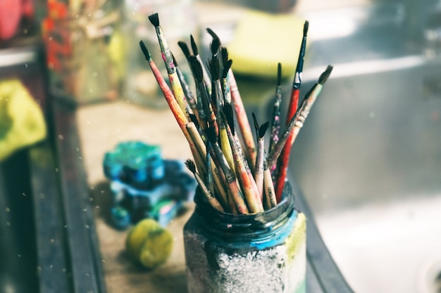 Photo creative workshop of the artist. paint brushes in a jar. many brushes for painting in one place