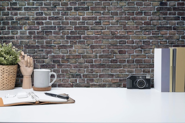 카메라 커피 컵 노트북과 흰색 테이블에 화초가 있는 창의적인 작업 공간 광고 텍스트를 위한 공간 복사