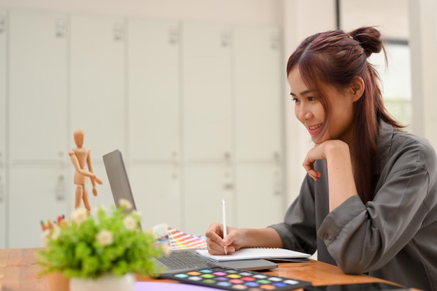 Creative young asian female graphic designer working at her office desk in the office room