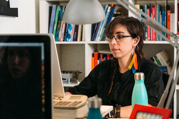 Creative young woman with colorful earrings working next to her partner