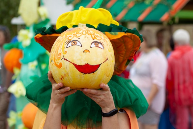 Creatively decorated Halloween pumpkins in human hands