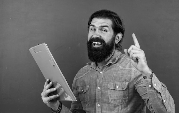 Creativity brutal bearded man work in classroom with documents prepare for exam college lecturer on lesson back to school formal education cheerful mature teacher making notes in paper