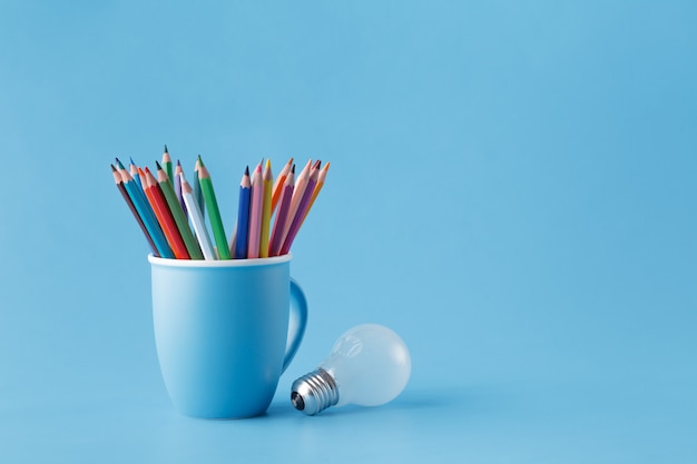 Creativity idea concept with mug oÐ° pencils and light bulb