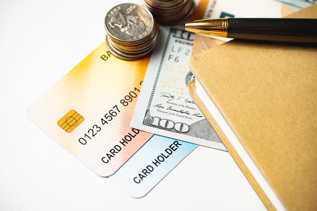 Credit bank cards with notepad and money on the table