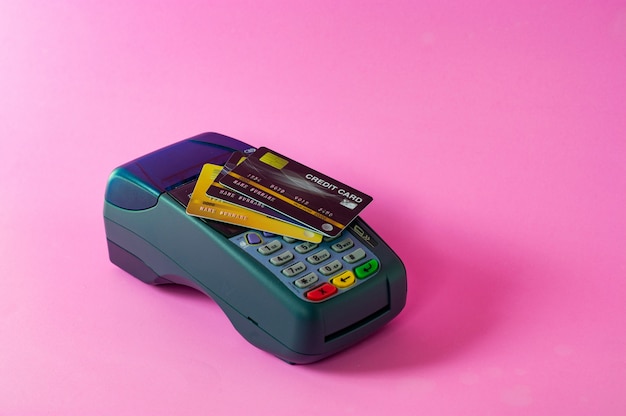 Foto scanner per carte di credito e carte di credito su sfondo rosa
