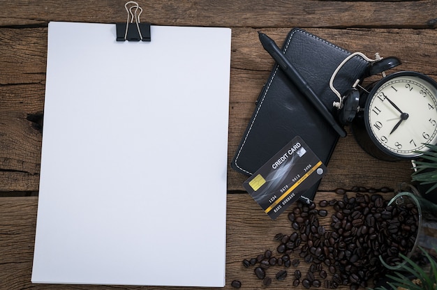 Credit card document smartphone coffee beans placed on a wooden table top view