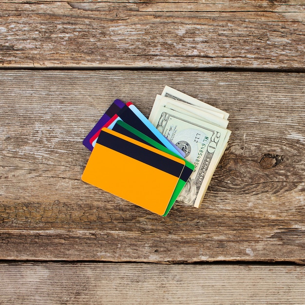 Credit card and dollars on wooden background. 