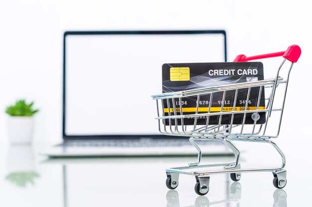 Credit card front of laptop screen with hand sanitizer and surgical mask