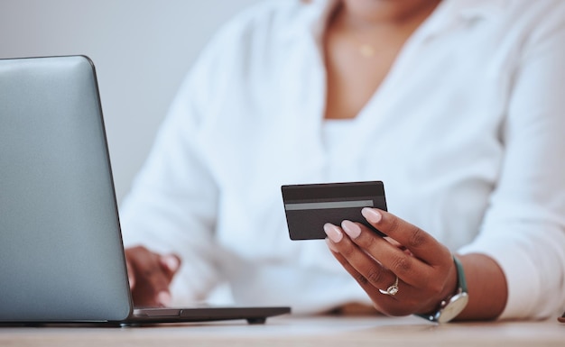 Credit card online payment and shopping being done with a laptop by a businesswoman manager or entrepreneur One female purchasing buying and ordering products on the internet or a website