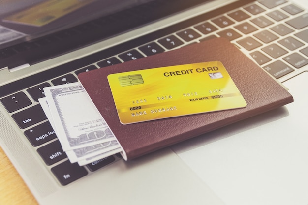 Credit card and passports near laptop computer on table. Online ticket booking concept