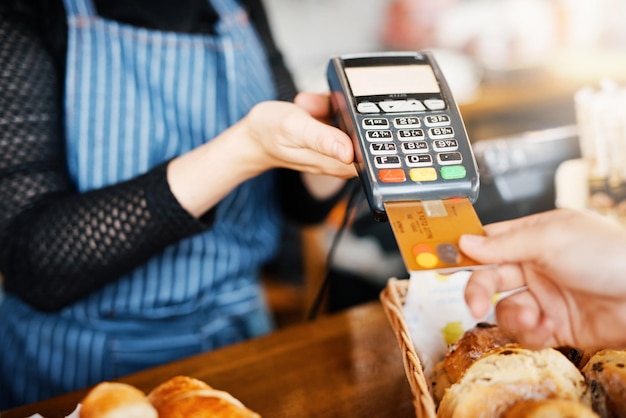 Foto pagamento con carta di credito panificio e mani con un distributore automatico in un ristorante per un servizio o un cibo paga al bar e un cliente che paga o acquista un prodotto in un bar con una transazione da un lavoratore