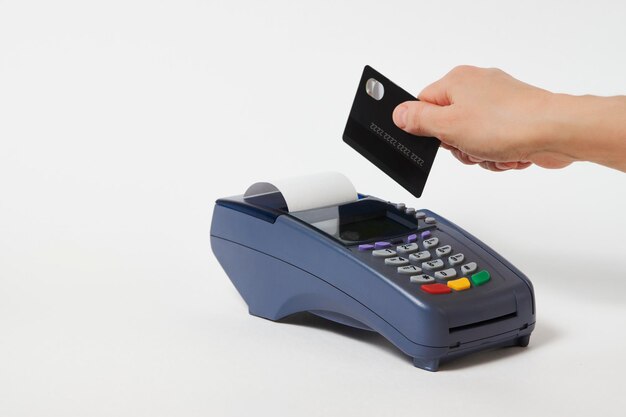 Credit card payment, buy and sell service. Woman hand with credit card and payment terminal on white background, close-up