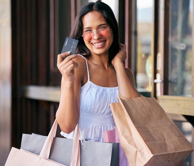 Credit card sunglasses and woman with shopping bags at mall ready to buy fashion clothing Black Friday sales deals and portrait of rich female from India with money and finance for retail payment