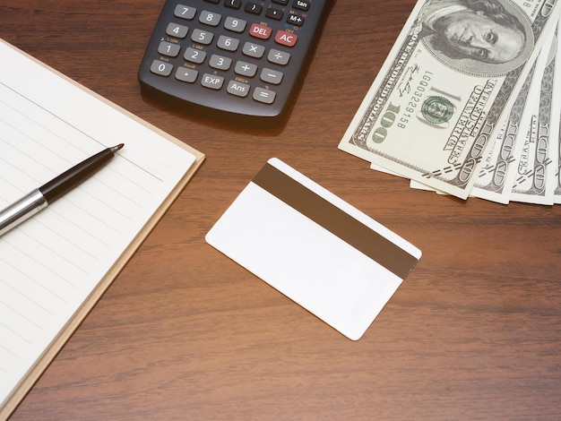 Credit card with calculator workspace and money on table top\
view