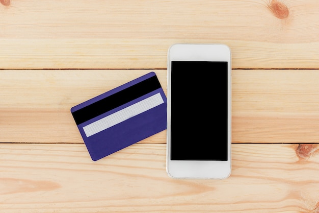 Credit card with smartphone on table, Top view with copy space. Online shopping concept