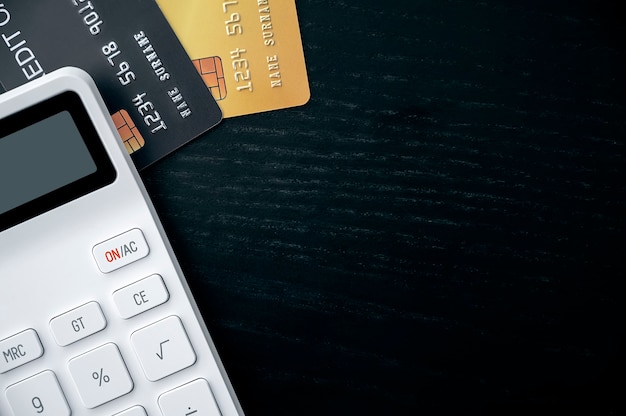 Photo credit cards and calculator on black wooden table