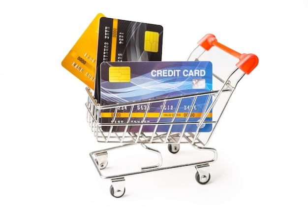 Credit cards in shopping cart isolated on white surface. .