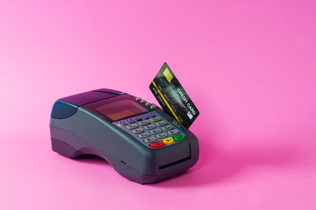 Creditcard en creditcardscanner op een roze achtergrond