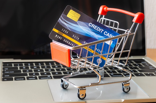 Creditcard en kar supermarkt op houten tafel. winkelen concept