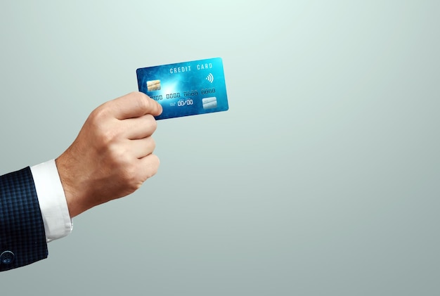 Creditcard in de hand van een zakenmanclose-up. Betalen met nfc, contactloos betalingssysteem, winkelen, elektronisch geld.