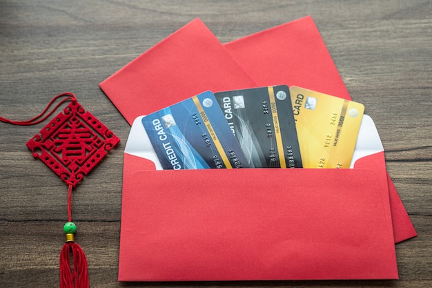 Creditcard in rode envelop met de Chinese tekst zegeningen erop geschreven Is een lente voor Chinees Nieuwjaar Festival bonus op houten tafel achtergrond.