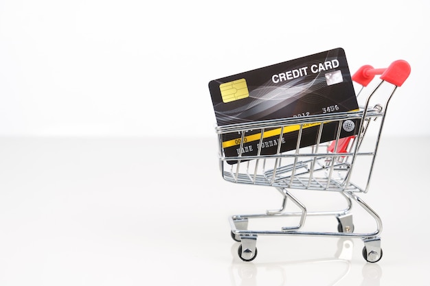 Foto creditcard in winkelwagen voor online winkelen op wit, werk vanuit huis concept