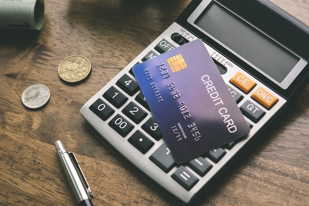 Creditcard met calculator en wat geld op de tafel