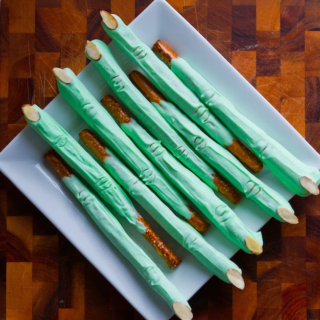 Creepy green Halloween pretzel treats on a white plate