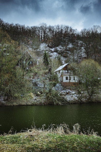 Foto collina inquietante con case abbandonate e un lago in una giornata nuvolosa