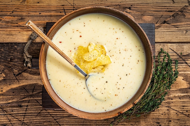 Crème aardappelsoep met chips in houten plaat. houten achtergrond. Bovenaanzicht.