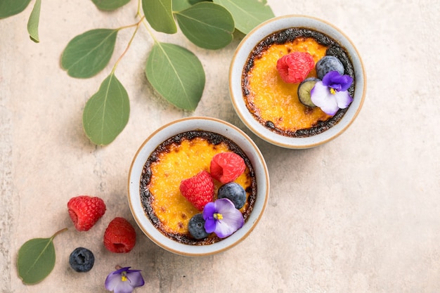 Creme brulee. French vanilla cream dessert with caramelised sugar and berries, selective focus.