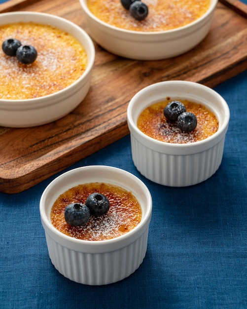 Creme brulee in lot of ramekin on wooden tray