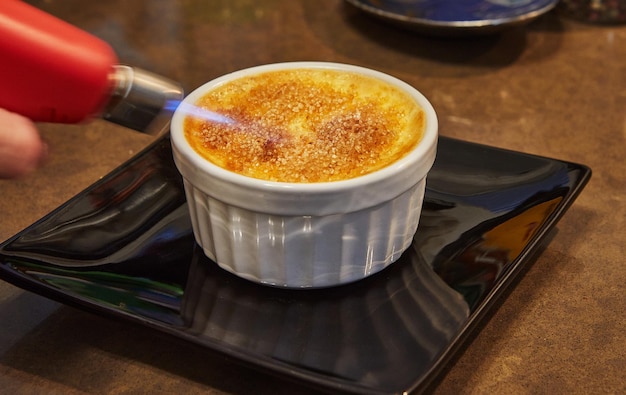 Creme brulee with mushrooms in special form the chef burns sugar with burner French gourmet cuisine