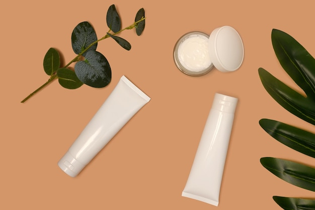 Crème en lotion in een witte plastic huidcontainer Tak van eucalyptus en palm